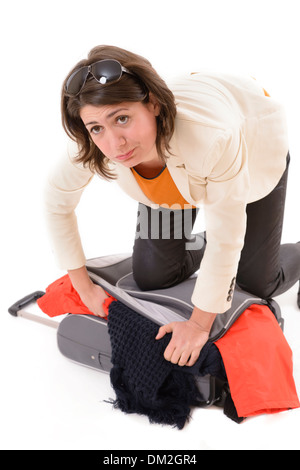 Attractive woman trying to close her suitcase Stock Photo