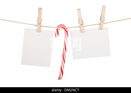 Blank photos and candy cane hanging on clothesline. Isolated on white background Stock Photo