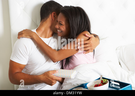 Man Bringing Woman Breakfast In Bed On Celebration Day Stock Photo