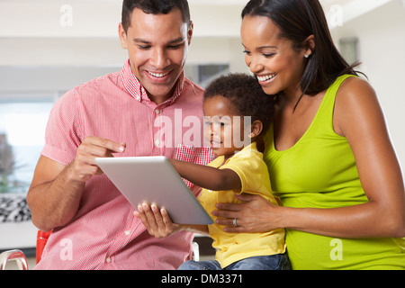 Family Using Digital Tablet In Kitchen Together Stock Photo