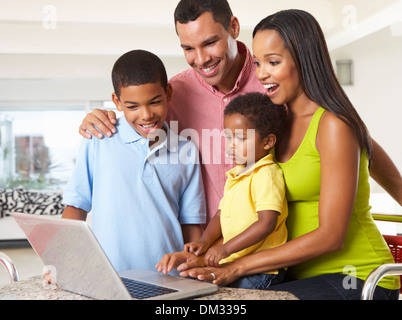 Family Using Laptop In Kitchen Together Stock Photo