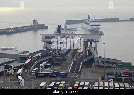 Ferries dock at the port of Dover, Kent, UK. Lorries are shown leaving one ferry as another maneuvers in the harbour Stock Photo