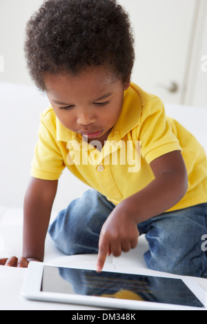 Happy Boy On Sofa Playing With Digital Tablet Stock Photo
