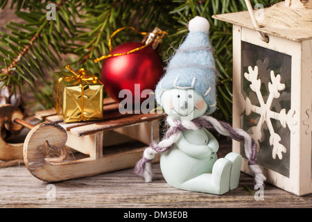 Christmas lantern with snowman and christmas tree on vintage wooden background Stock Photo