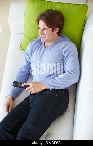 Overhead View Of Man Relaxing On Sofa Watching Television Stock Photo