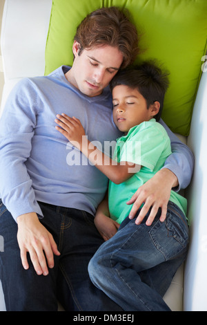 Overhead View Of Father And Son Relaxing On Sofa Stock Photo