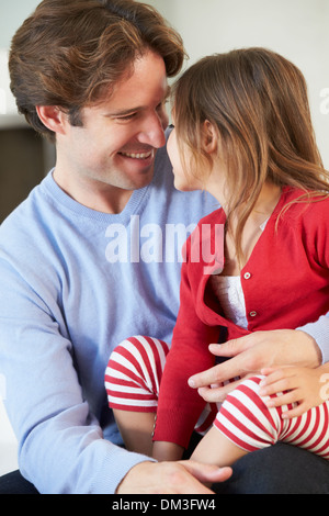 Father And Daughter Relaxing On Sofa Together Stock Photo