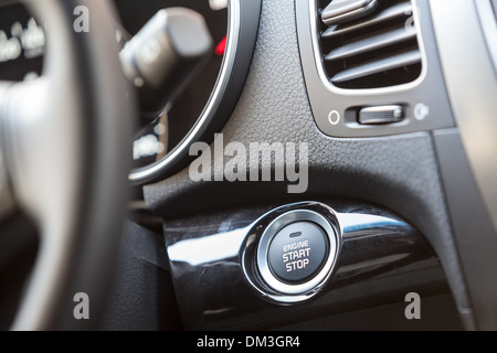 Car interior, engine start button under the steering wheel Stock Photo