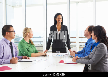 Businesswoman Conducting Meeting In Boardroom Stock Photo