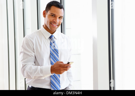 Businessman Using Mobile Phone In Office Stock Photo