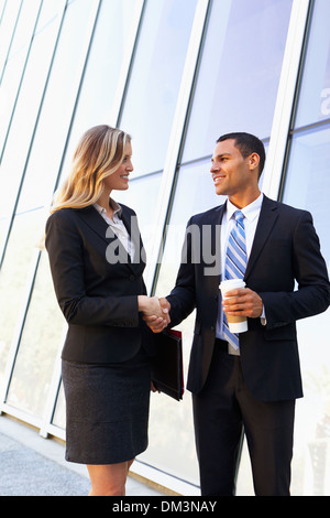 Businessman And Businesswomen Shaking Hands Outside Office Stock Photo