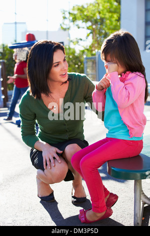 Teacher Comforting Upset Elementary School Pupil Stock Photo