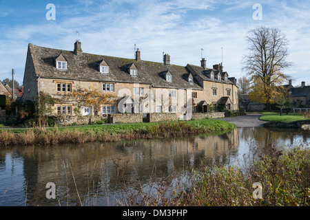 Pretty limestone houses by the River Eye in Lower Slaughter in the Cotswolds UK Stock Photo
