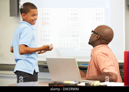 Male Student Writing Answer On Whiteboard Stock Photo
