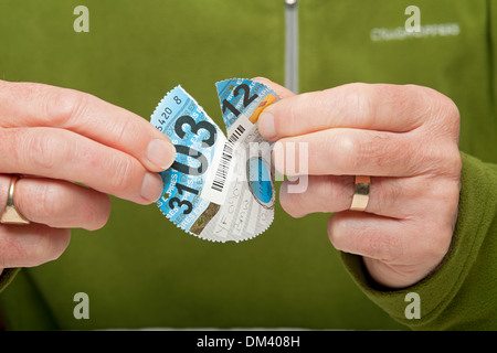 Close up of man person holding car tax disc End of British road fund tax discs England UK United Kingdom GB Great Britain Stock Photo