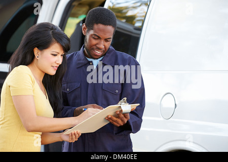 Customer Signing For Delivery From Courier Stock Photo
