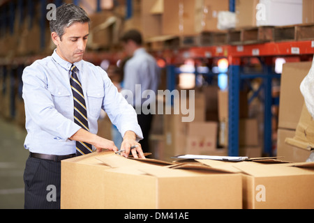 Manager In Warehouse Checking Boxes Stock Photo