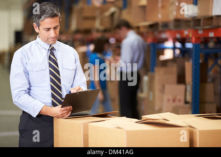 Manager In Warehouse Checking Boxes Stock Photo
