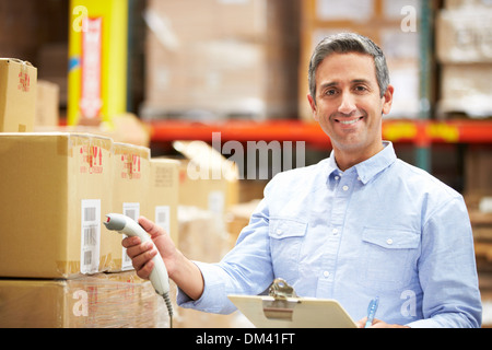 Worker Scanning Package In Warehouse Stock Photo