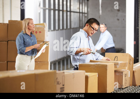 Workers Checking Goods On Belt In Distribution Warehouse Stock Photo
