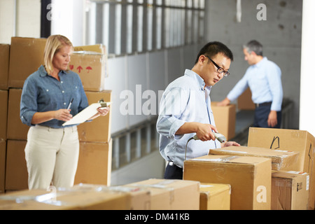 Workers Checking Goods On Belt In Distribution Warehouse Stock Photo