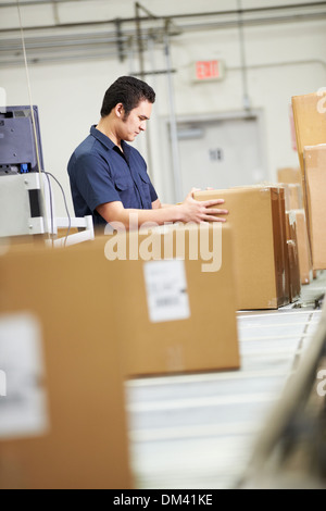 Worker Checking Goods On Belt In Distribution Warehouse Stock Photo