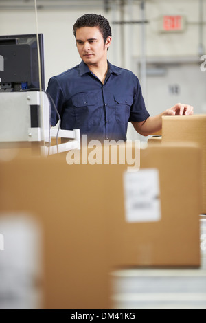 Worker Checking Goods On Belt In Distribution Warehouse Stock Photo