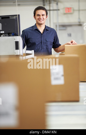Worker Checking Goods On Belt In Distribution Warehouse Stock Photo