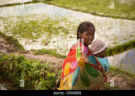 A girl holds a small child in Fenerive Est District, Madagascar Stock Photo