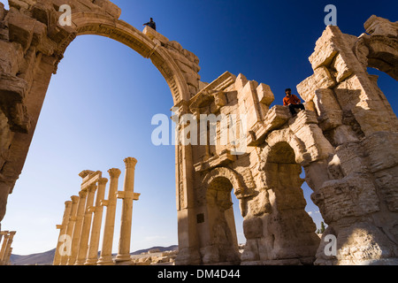 People on top of the monumental arch of the ruins at Palmyra, Syria Stock Photo