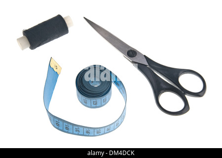 Thread on a reel, tape-line and scissors over white background Stock Photo