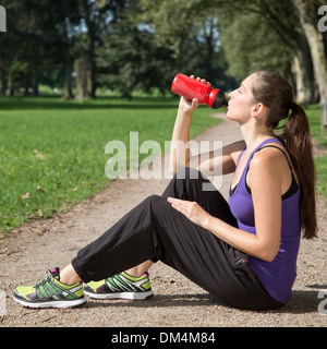 Young woman takes a break for drinking during sports or running Stock Photo