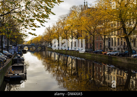 TREE LINED DUTCH CANAL IN AMSTERDAM HOLLAND AND AUTUMN COLOURED