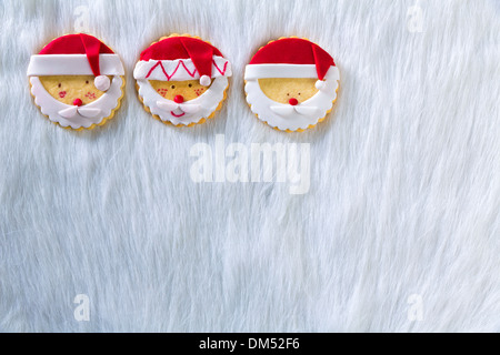 Christmas cookies with santa face on white fur background with copy space Stock Photo