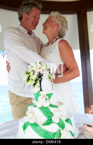 Senior Beach Wedding Ceremony With Cake In Foreground Stock Photo
