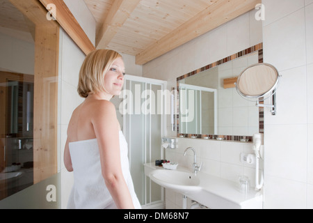 Woman standing in a bathroom Stock Photo