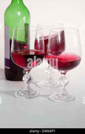 Red wine poured in three glasses. Stock Photo