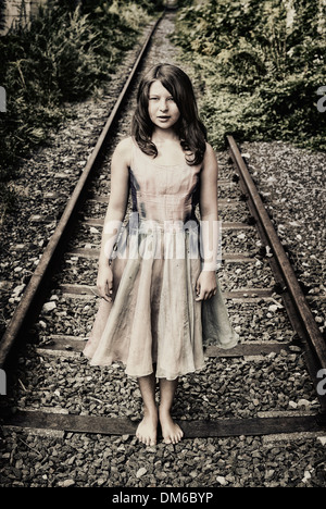 Girl standing on a railroad track Stock Photo