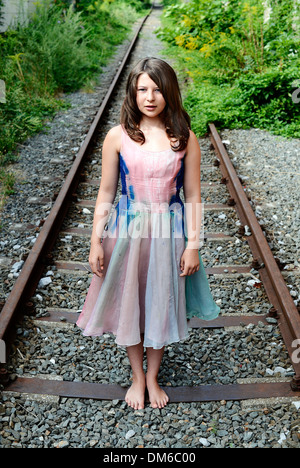 Girl standing on a railroad track Stock Photo