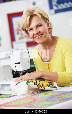 Portrait Of Woman Using Electric Sewing Machine Stock Photo