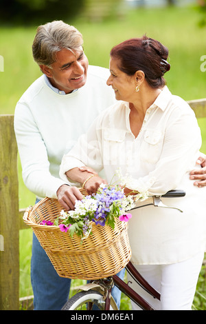 Senior Indian Couple On Cycle Ride In Countryside Stock Photo