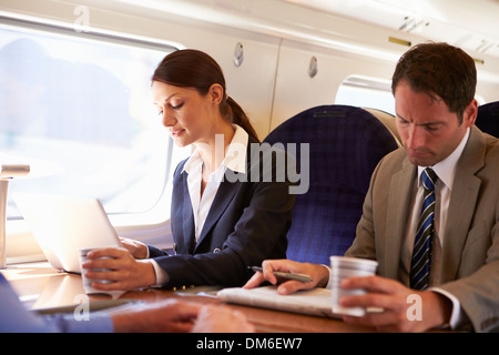 Businesswoman Commuting To Work On Train And Using Laptop Stock Photo