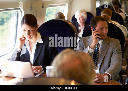 Businesswoman Commuting To Work On Train And Using Laptop Stock Photo
