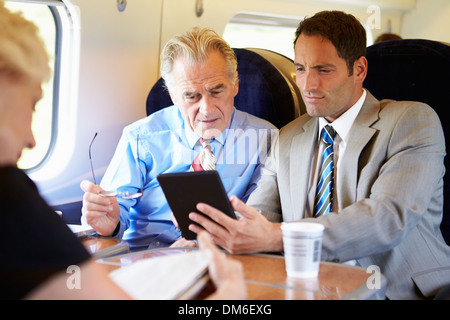 Two Businessmen Having Meeting On Train Stock Photo