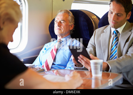 Businessman Resting On Train Journey Stock Photo