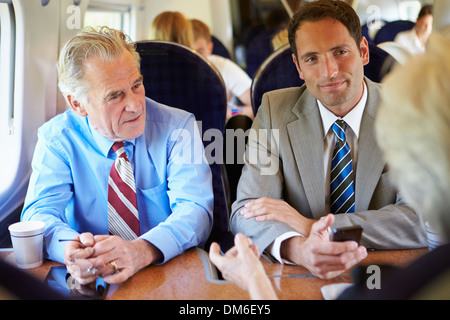 Group Of Businesspeople Having Meeting On Train Stock Photo