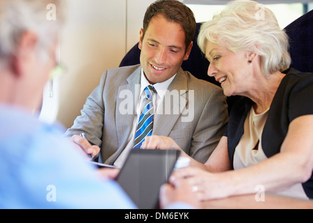 Businesspeople Having Meeting On Train Stock Photo
