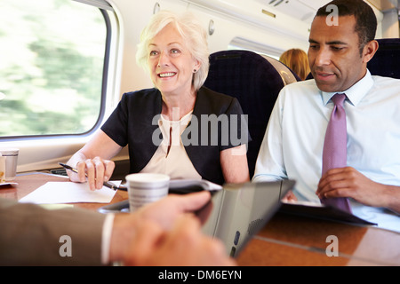 Group Of Businesspeople Having Meeting On Train Stock Photo