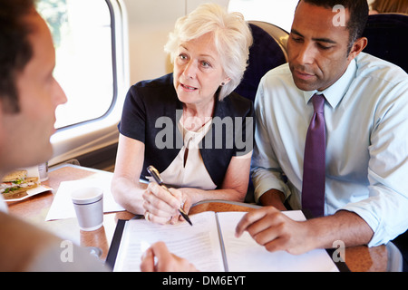 Group Of Businesspeople Having Meeting On Train Stock Photo