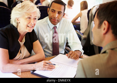 Group Of Businesspeople Having Meeting On Train Stock Photo